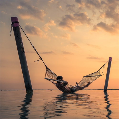 person in hammock on ocean