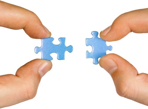 person holding two puzzle pieces