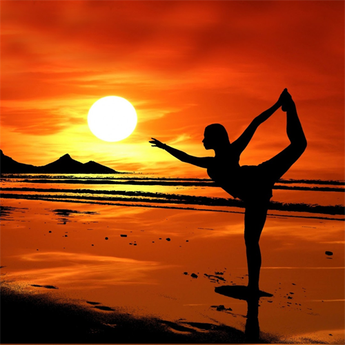 person doing warrior yoga pose on beach